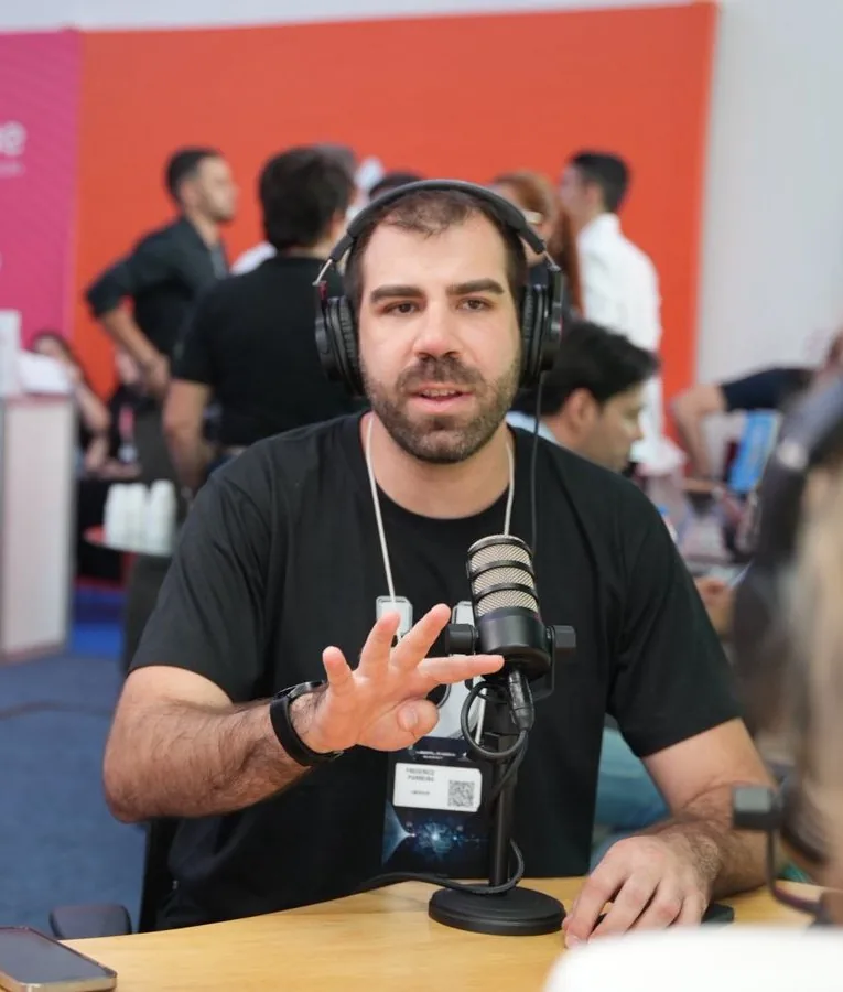 Fred Parreira de fones, conversando ao microfone durante gravação em um evento